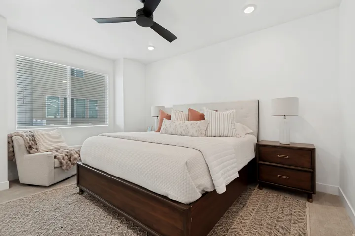 Recessed lighting, a ceiling fan, and a large window with blinds define the space