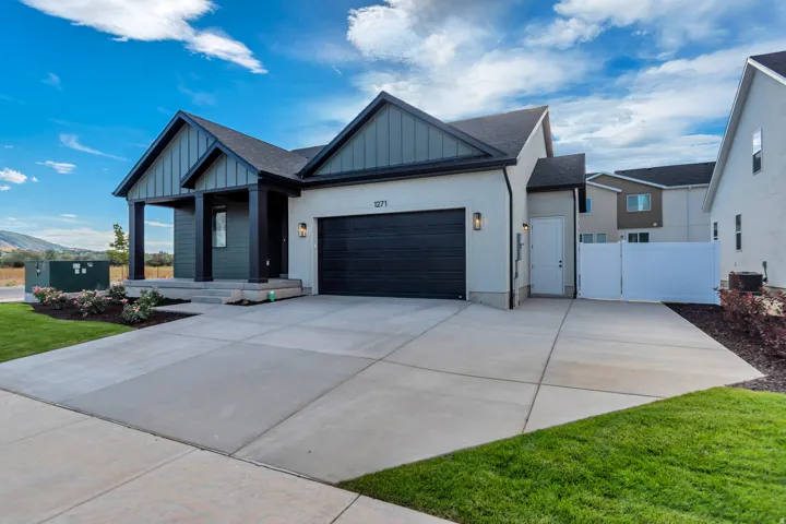 Contemporary exterior with a covered porch, attached garage, and a concrete driveway