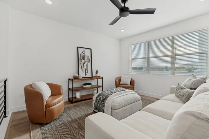 Recessed lighting illuminates this space, featuring wood-finish flooring, a contemporary ceiling fan, and multiple windows with horizontal blinds