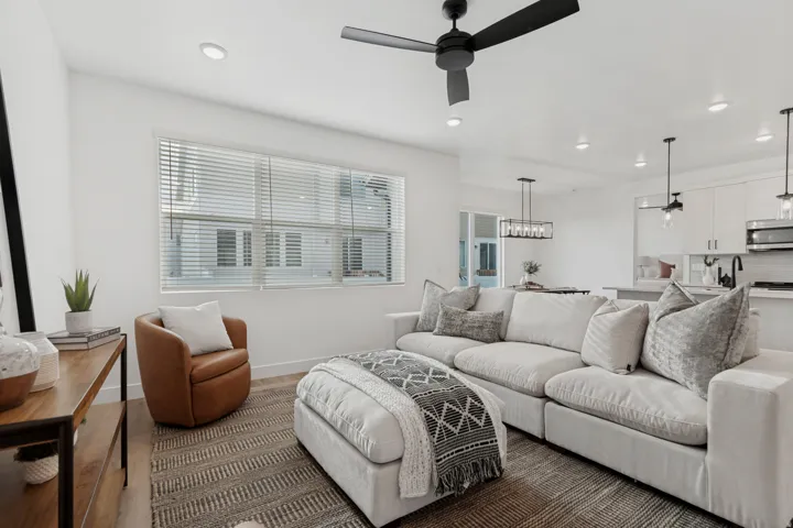 Recessed lighting throughout, a modern ceiling fan, and large windows with blinds