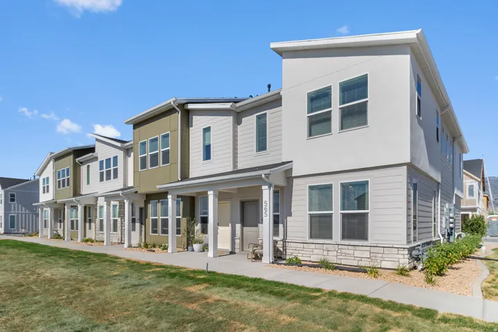 Modern townhome with a multi-level facade, stone detailing, and covered porch entry