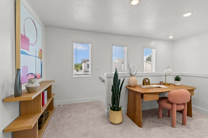 Carpeted open-concept space featuring white walls, recessed lighting, and multiple windows with blinds