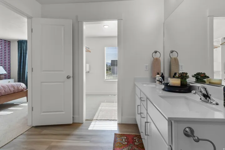 Dual vanity with integrated sinks, chrome faucets, and a large wall-mounted mirror