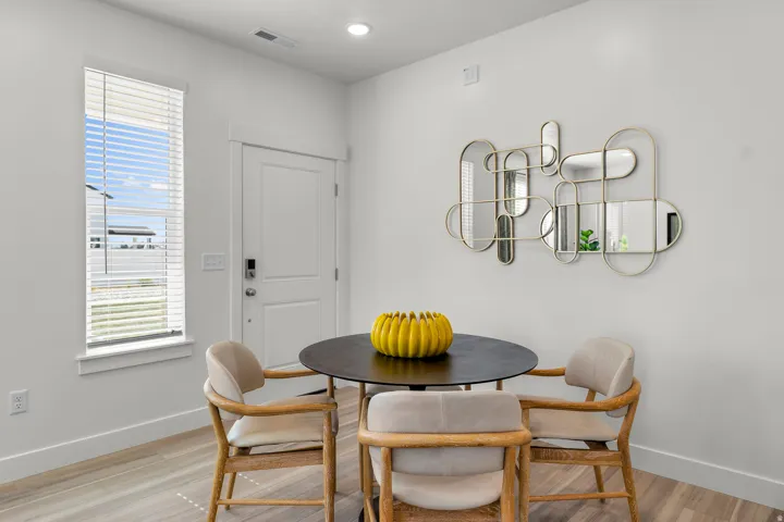 Contemporary wall-mounted mirror installation, white interior door, light wood-finish flooring, recessed lighting, and a single-pane window