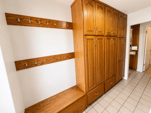 Built-in storage cabinetry with wood-finish doors and brass hardware