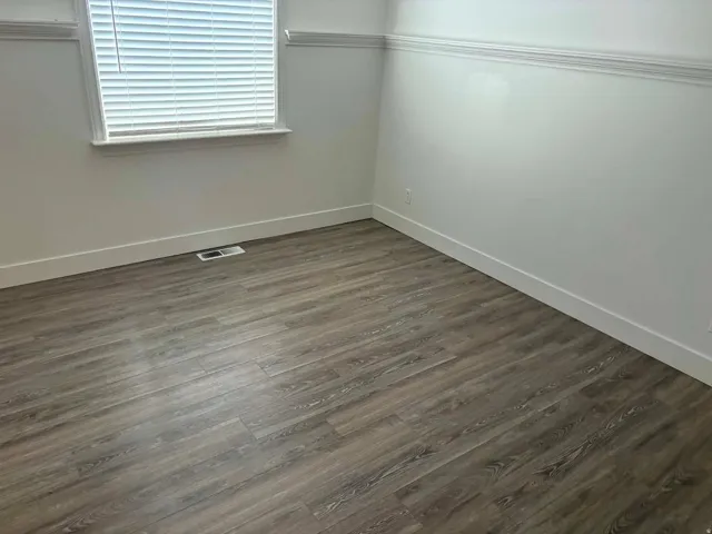Wood-finish flooring with crisp white baseboards and crown molding
