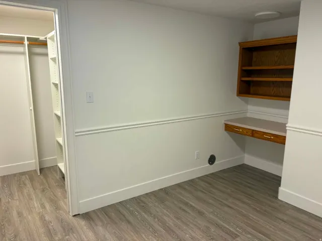 Wood-finish flooring, built-in desk, built-in shelving, built-in closet organization, and chair rail molding
