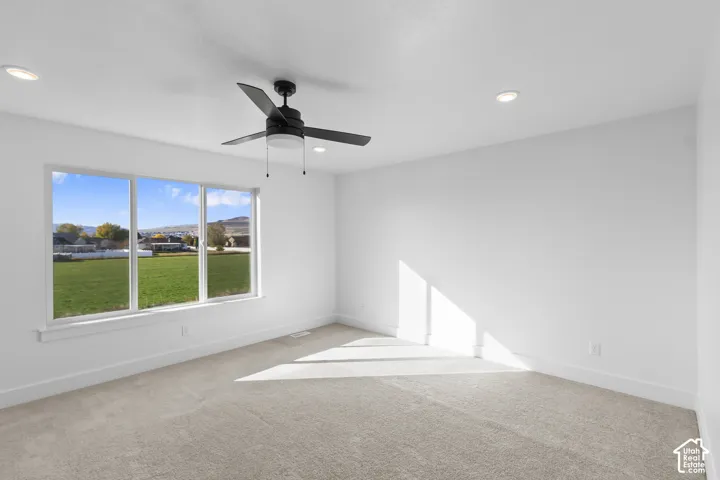 Recessed ceiling lights, a contemporary ceiling fan, and carpeted flooring