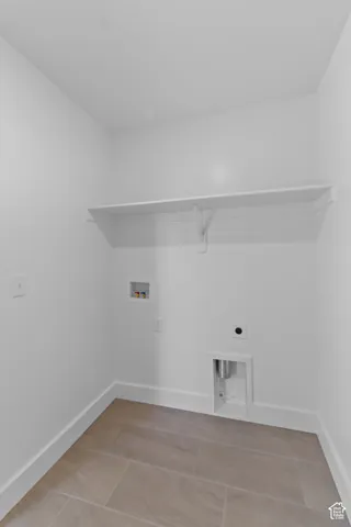 Laundry area with tile flooring and built-in shelving