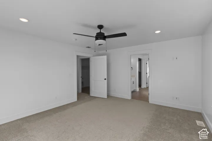 Recessed ceiling lights, ceiling fan with light fixture, neutral carpet flooring, white interior doors, and white trim