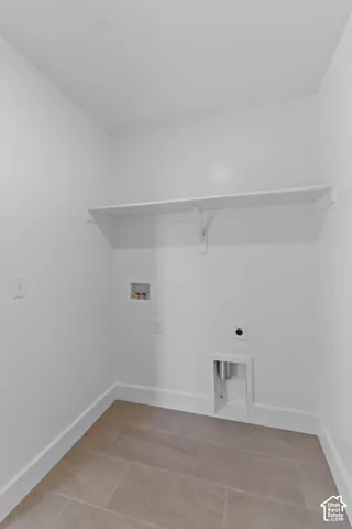 Laundry area with tile flooring and built-in shelving
