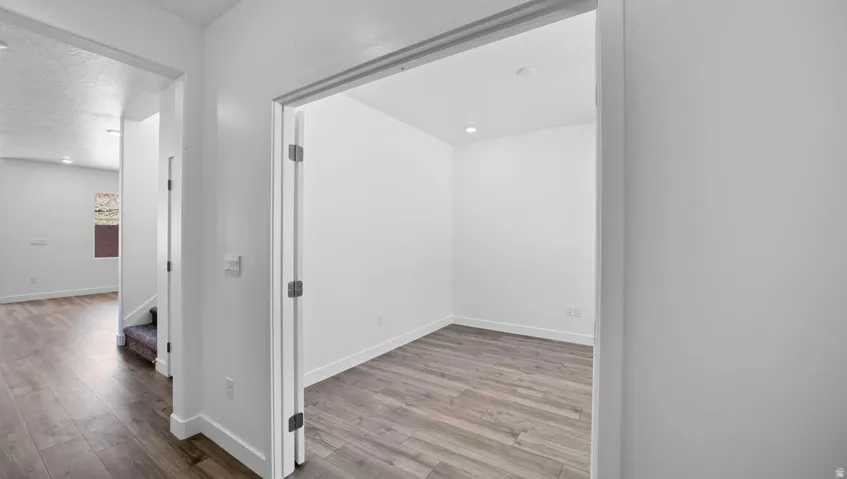 Entryway with wood-finish flooring and a room featuring recessed lighting