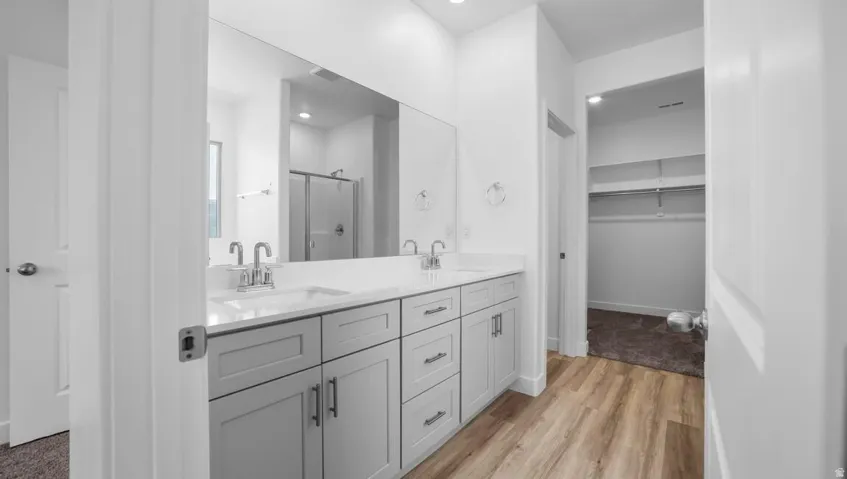Dual vanity with light gray cabinetry and chrome hardware