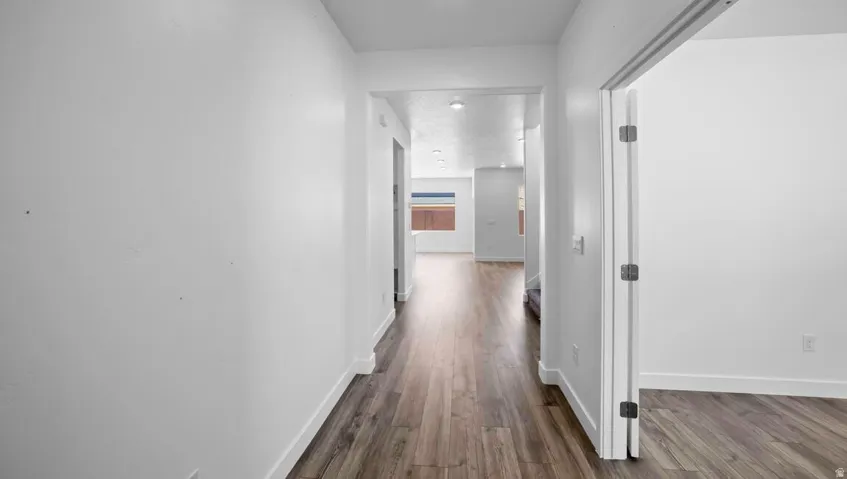 Wood-finish flooring throughout, white wall finishes, and recessed ceiling lighting