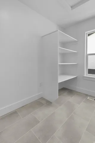 Built-in shelving, clean white walls, and a window with natural light
