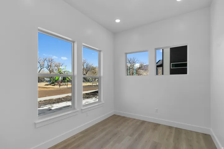 Bright interior with wood-finish flooring, recessed lighting, and multiple windows