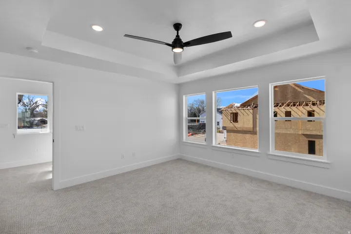 Recessed lighting, tray ceiling, ceiling fan, and multiple windows