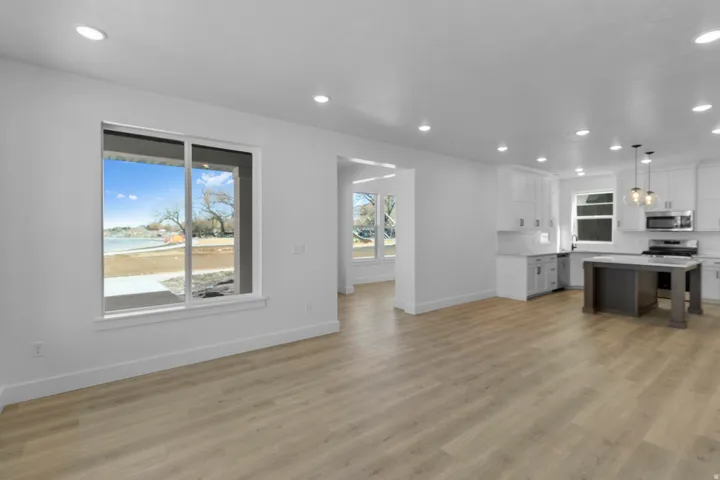 Open concept living area with wood-finish flooring, recessed lighting, and a modern kitchen