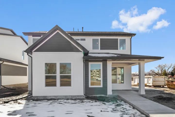 Contemporary exterior featuring white stucco, dark gray siding, and multiple large windows