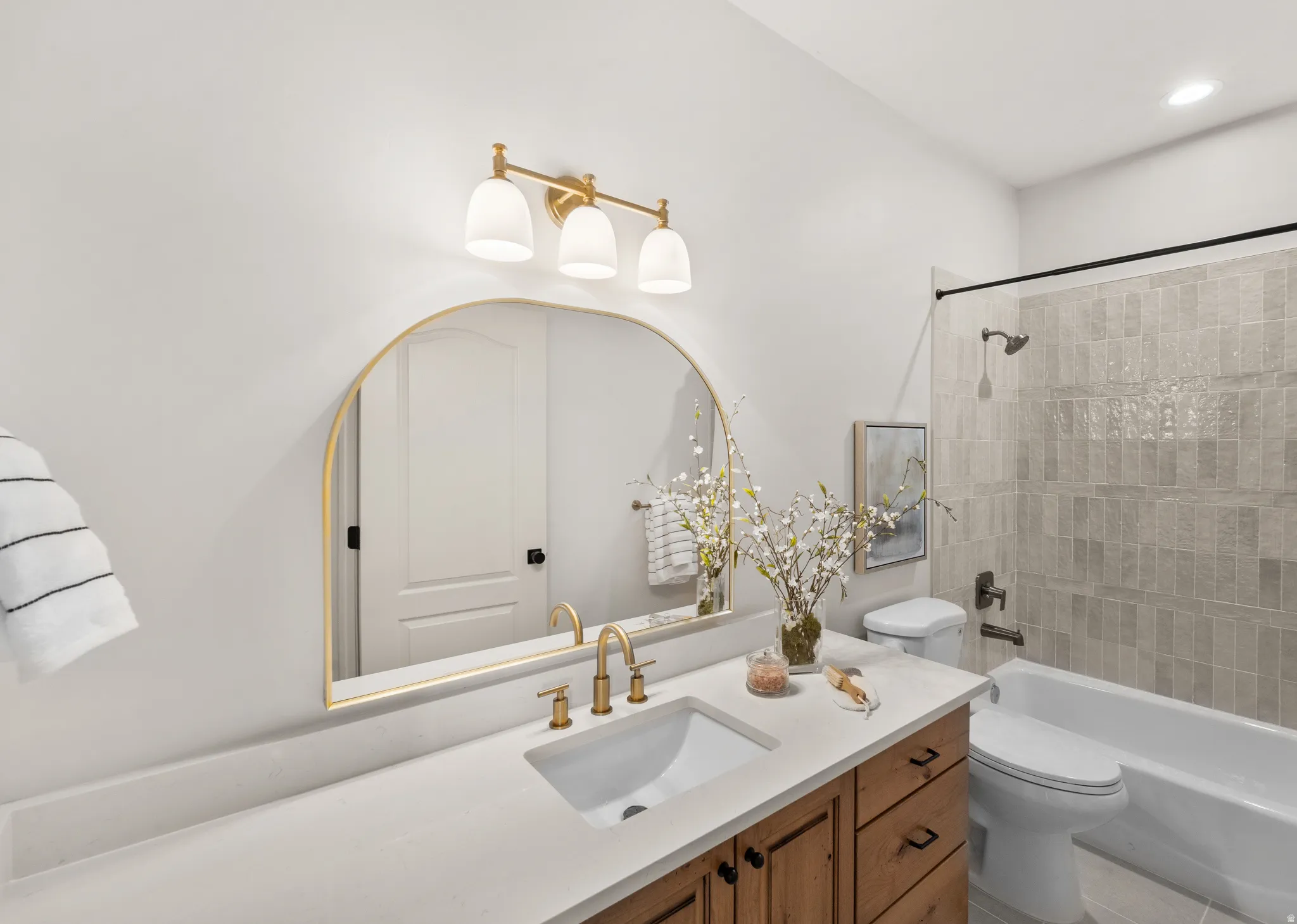 White countertop with an integrated sink and gold-finish faucet