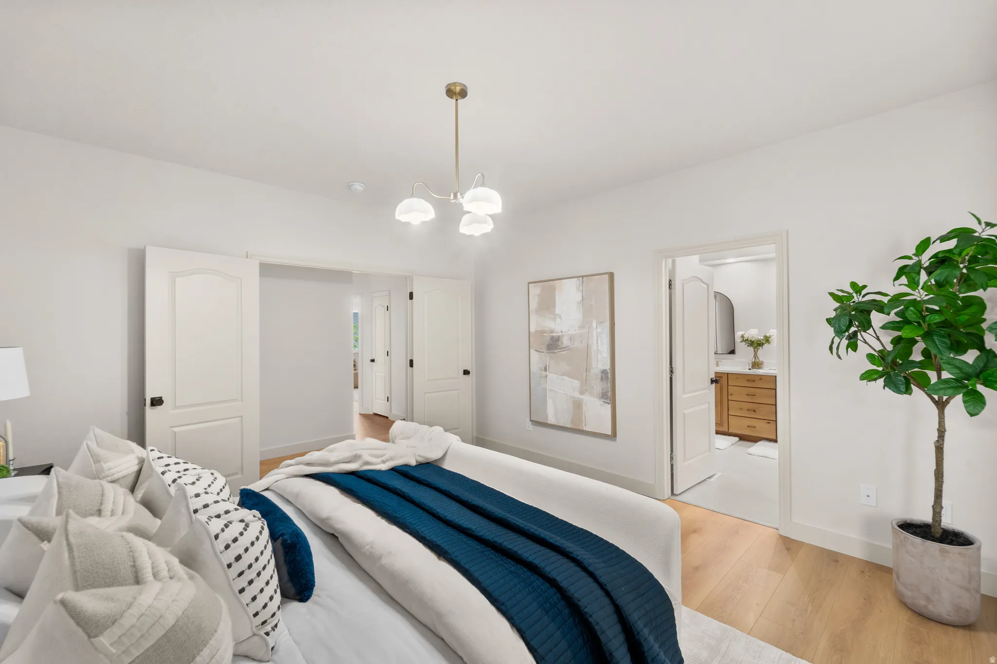 Recessed lighting, wood-finish flooring, white walls, white trim, and a brass-finish ceiling light fixture