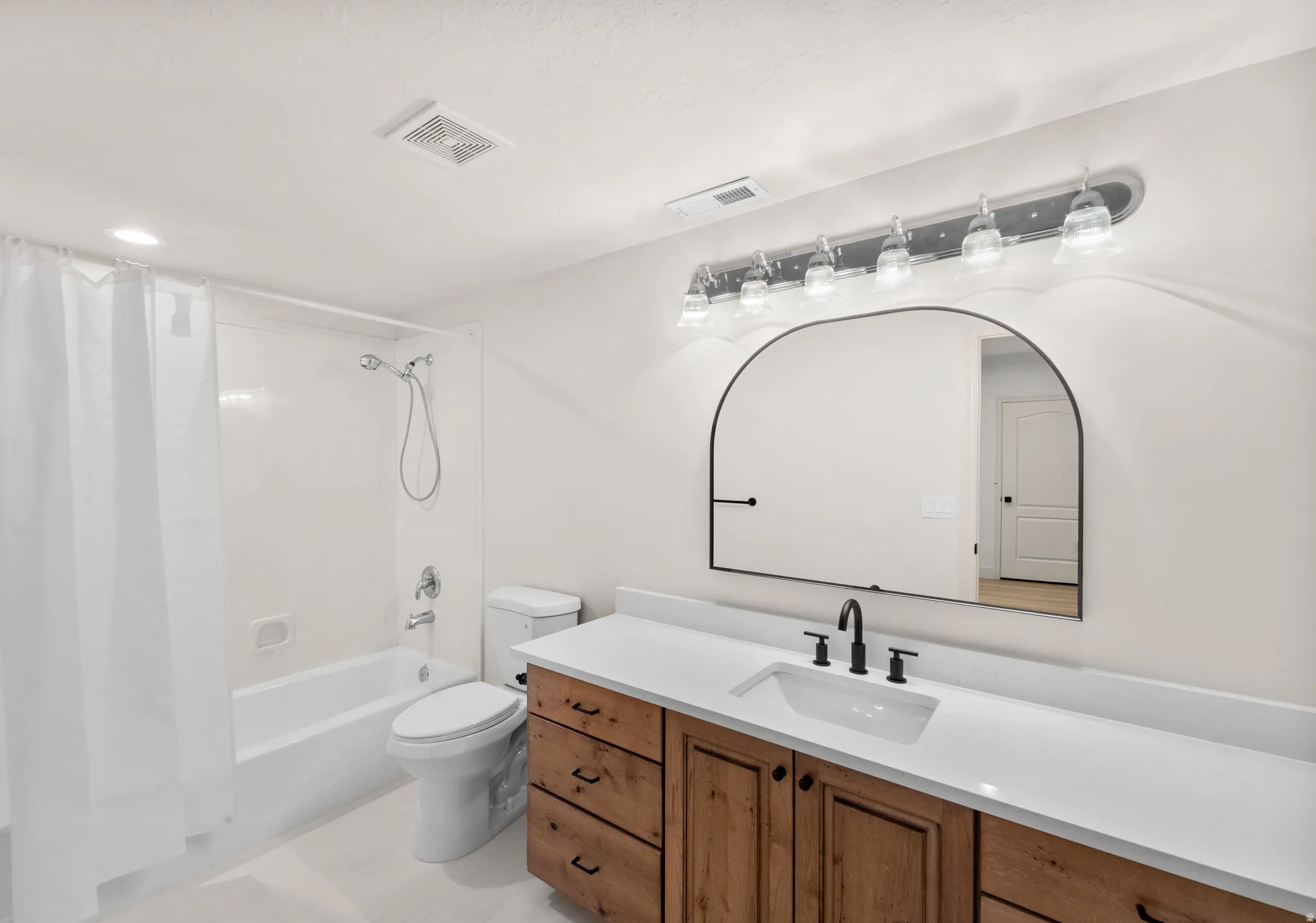 Wood-finish vanity with a white countertop and undermount sink