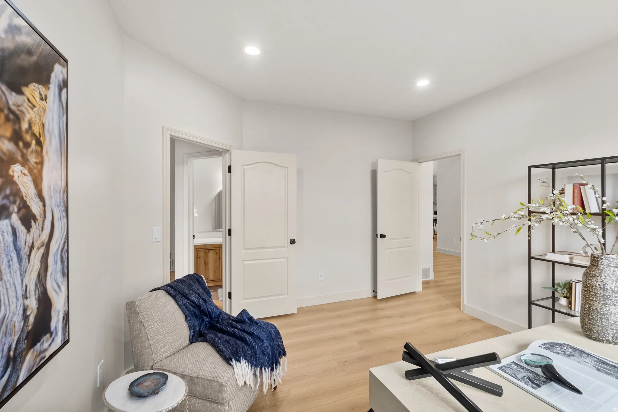 Recessed lighting illuminates the light wood-finish flooring