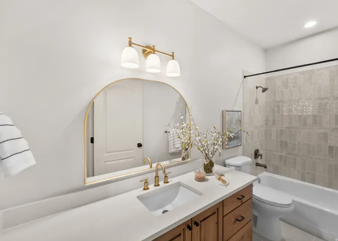 White countertop with an integrated sink and gold-finish faucet