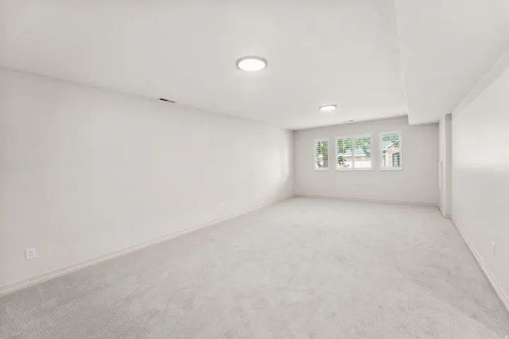 Expansive room with neutral carpeting and light-colored walls
