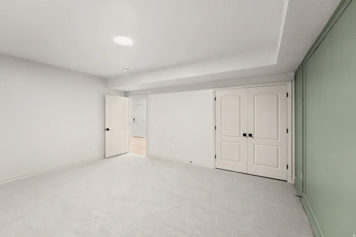 Recessed lighting, plush carpeting, paneled interior doors, and a decorative accent wall