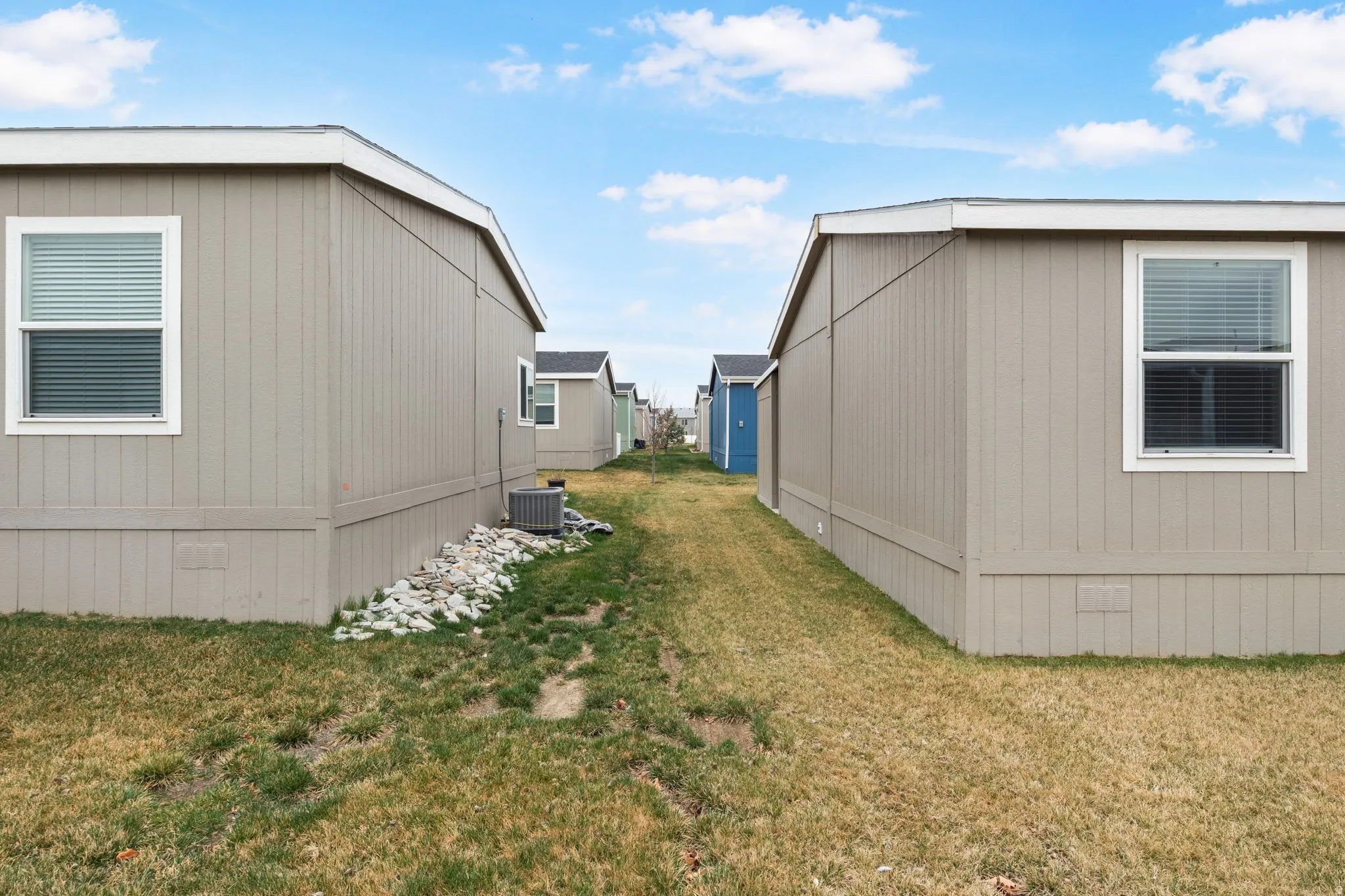 Beige vertical siding exterior with white window trim and white roofline