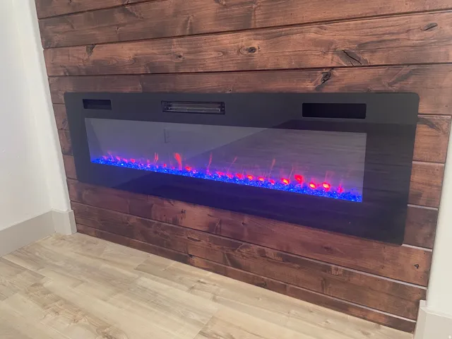 Integrated electric fireplace with colorful flame display and a horizontal plank wood-finish accent wall