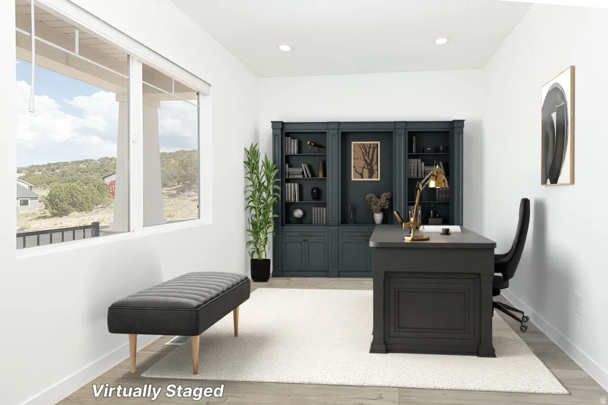 Spacious room featuring multiple windows, recessed lighting, and wood-finish flooring