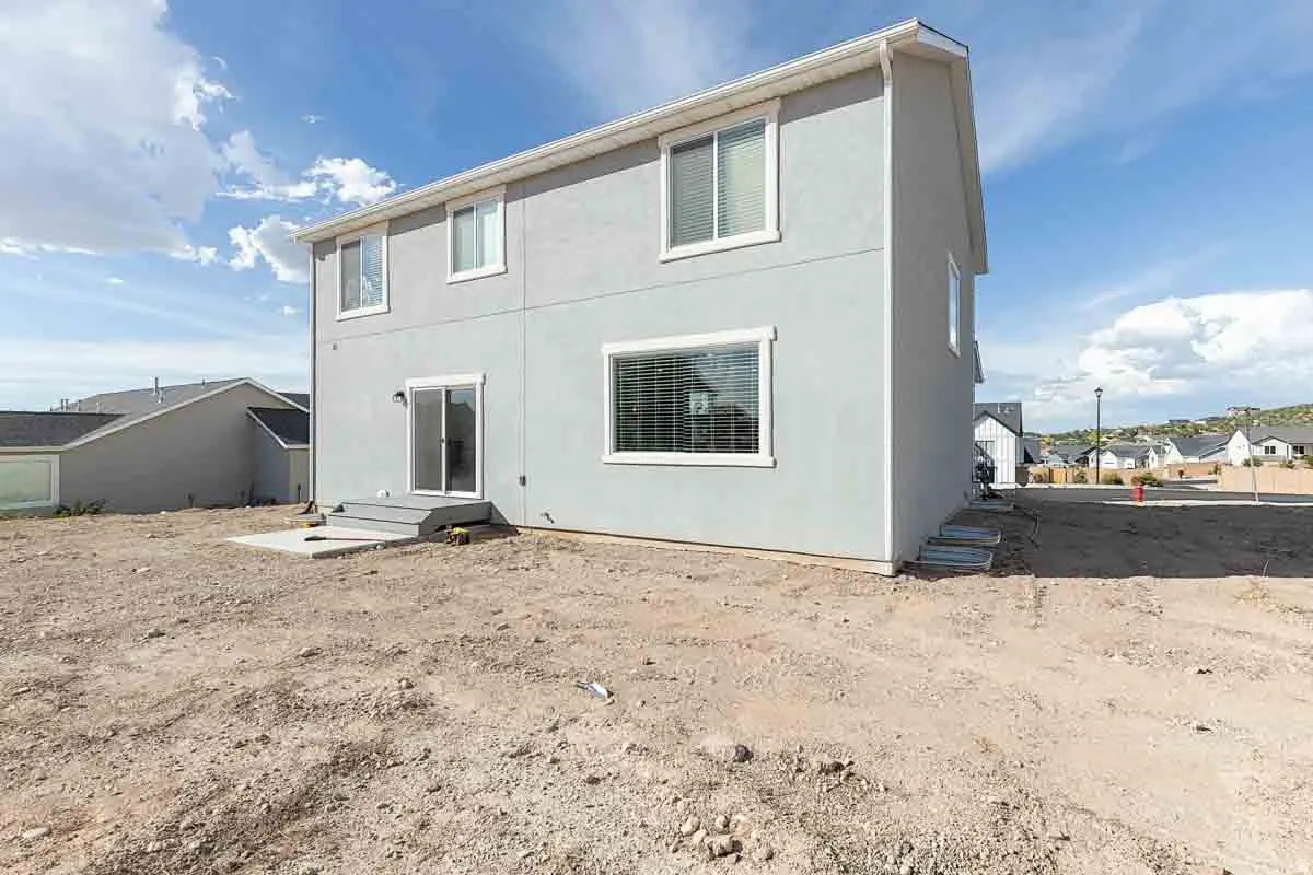 Modern two-story residence featuring clean-lined architectural design with expansive windows, crisp white exterior cladding, and a spacious ground-level foundation