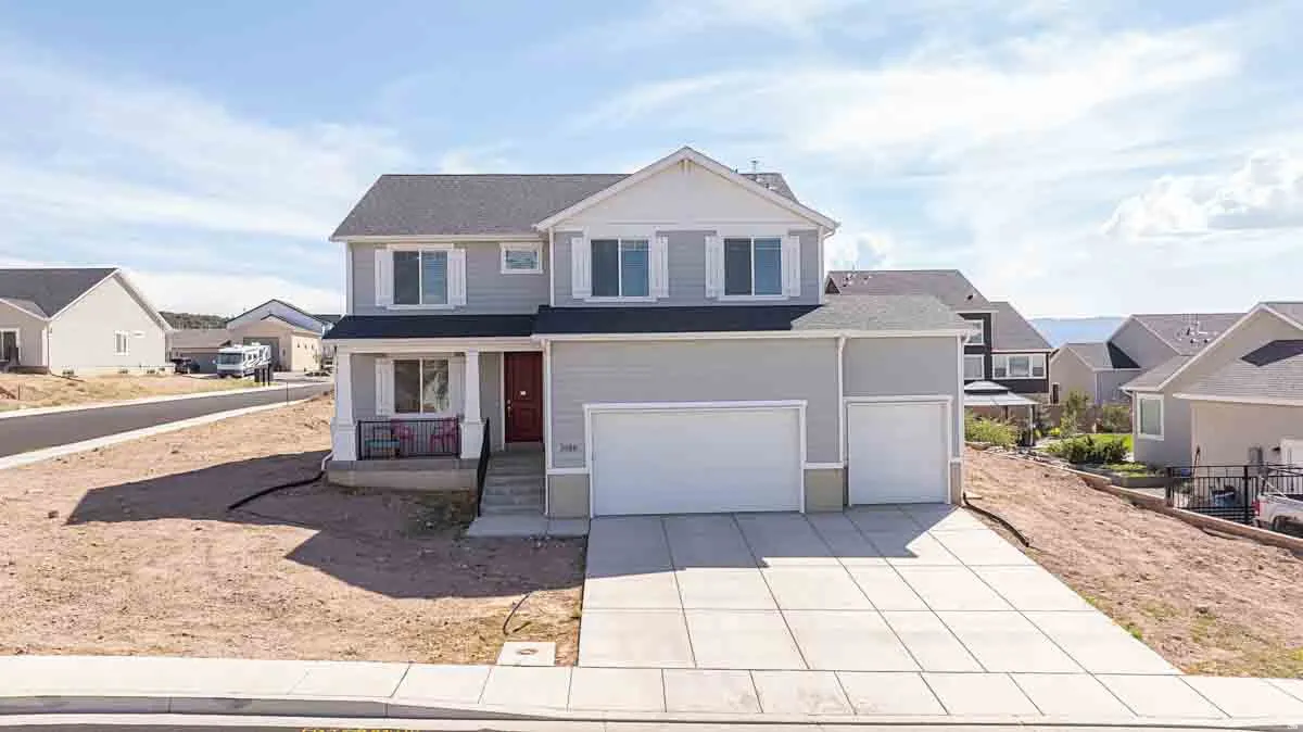 Two-story residence with a covered porch, a two-car garage, and a concrete driveway