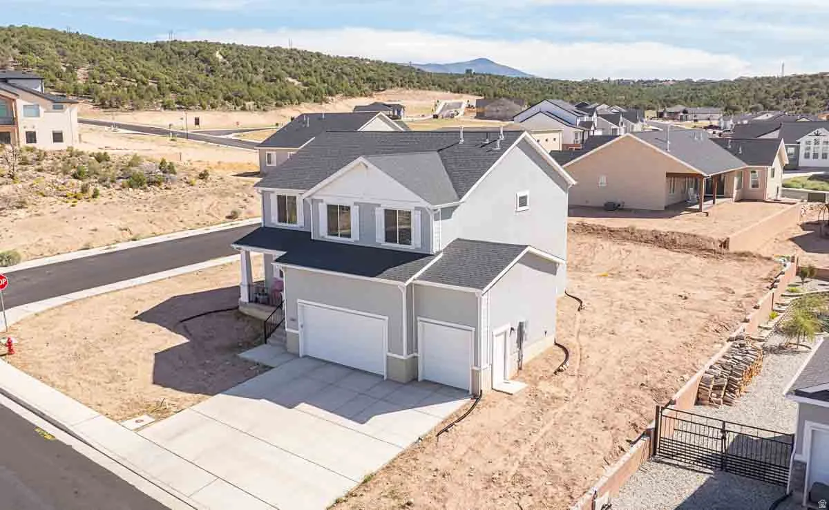 Two-story residence with a covered front porch, dual garage doors, and a concrete driveway