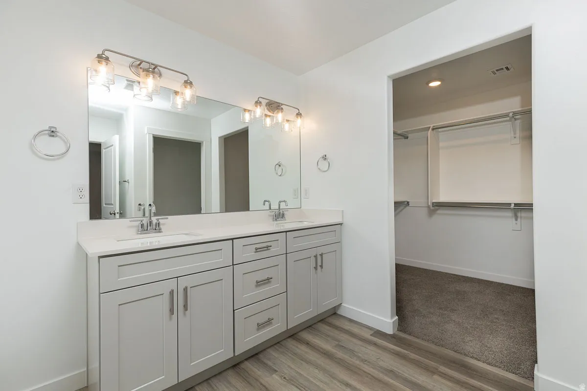 Dual vanity with light gray cabinetry, integrated sinks, and chrome fixtures