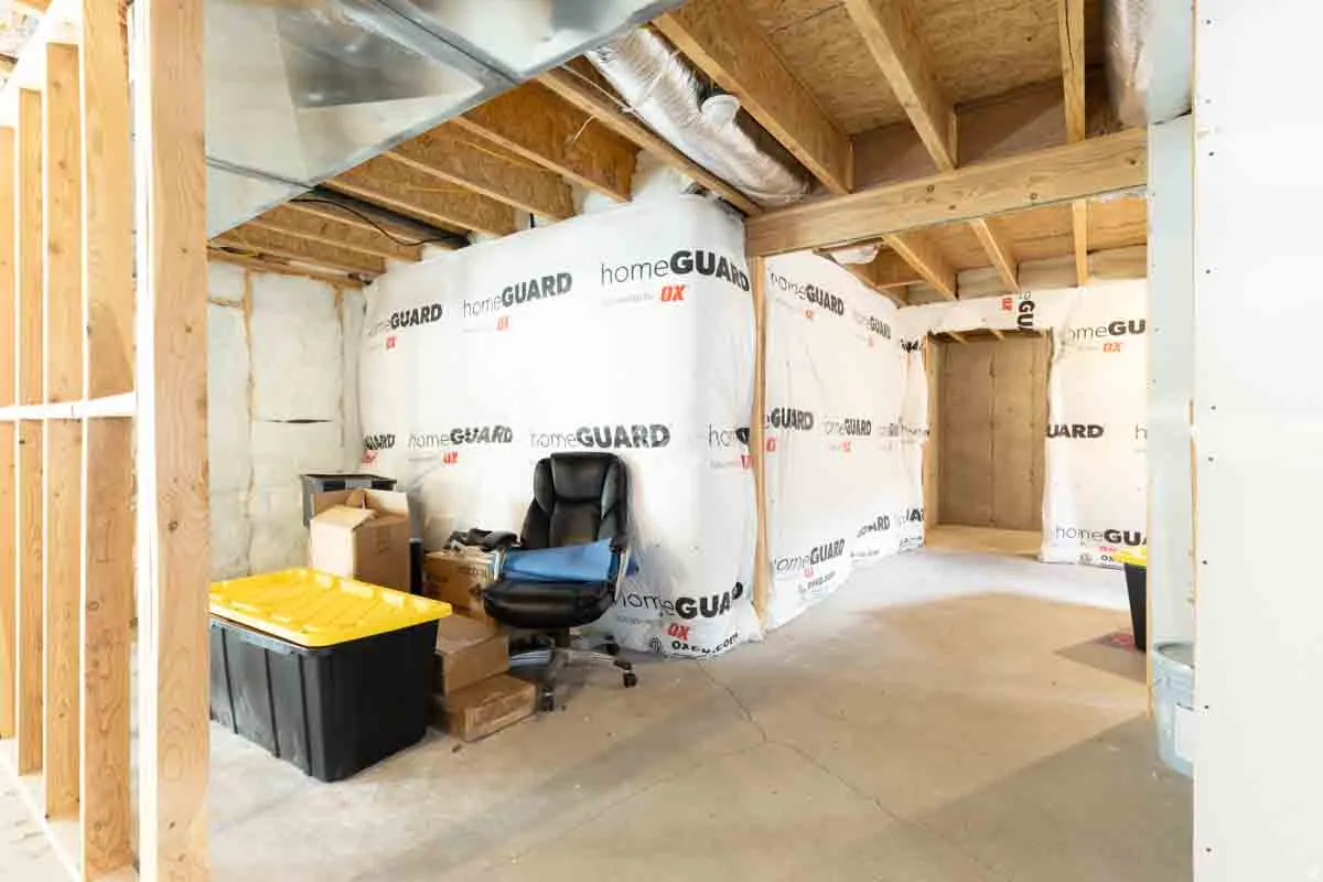 Unfinished basement featuring exposed wood framing, concrete flooring, and perimeter wall insulation