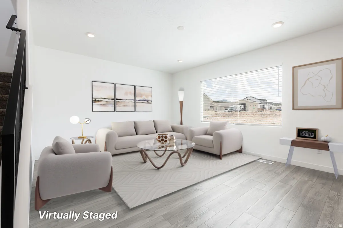 Recessed lighting illuminating a spacious room with wood-finish flooring