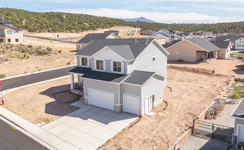 Two-story residence with a covered front porch, dual garage doors, and a concrete driveway