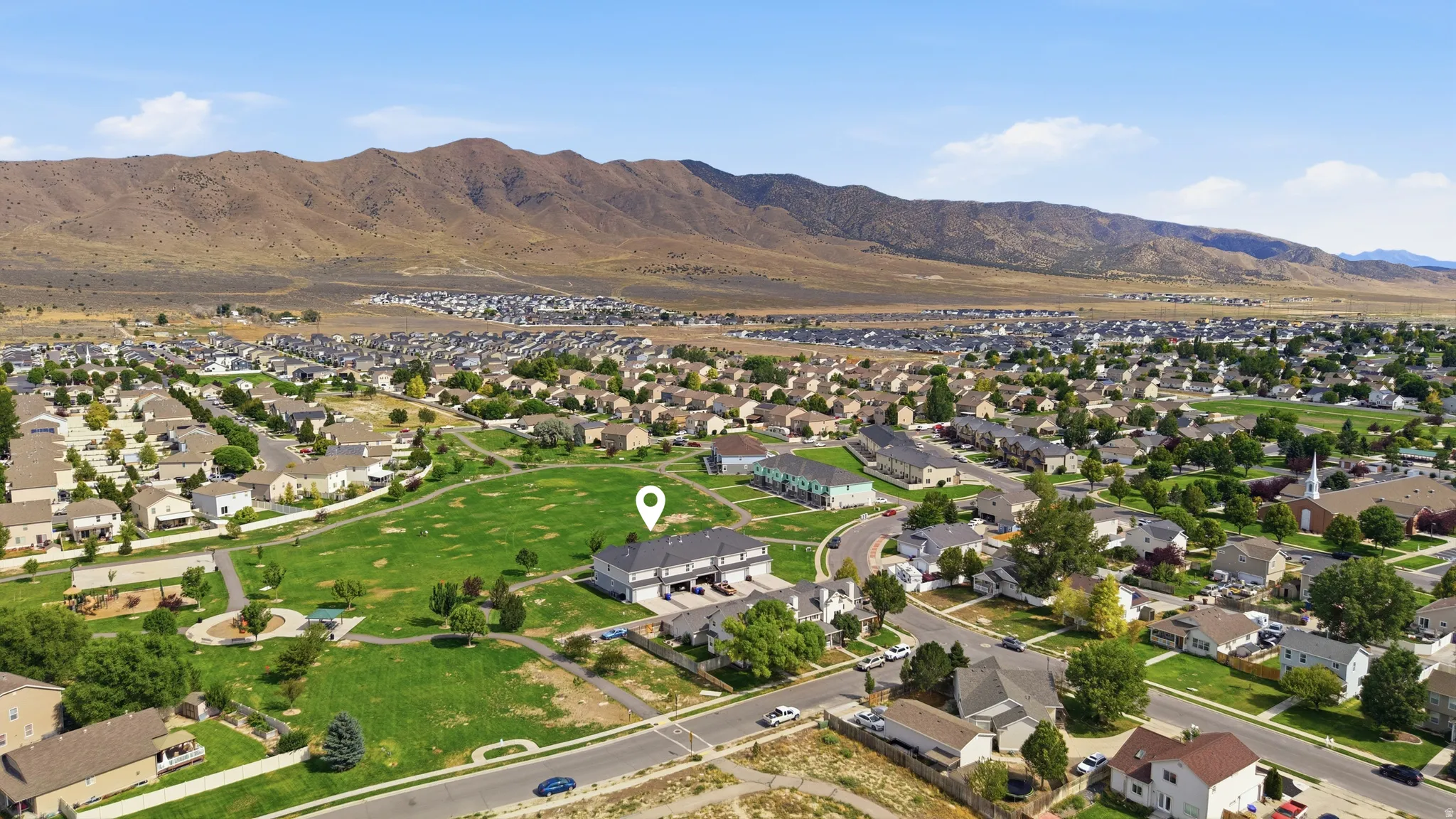 Townhome property adjacent to a green space with paved paths