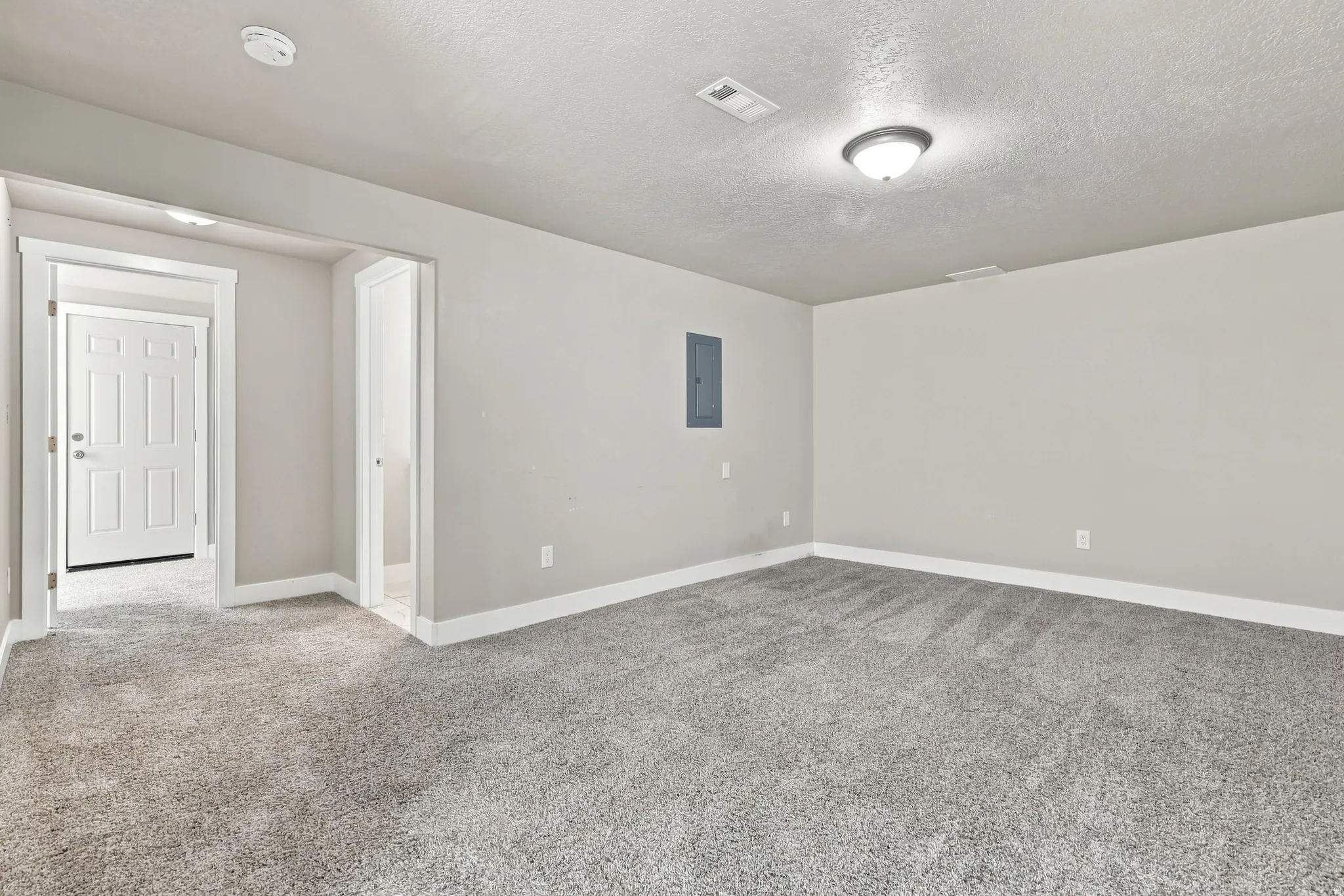 Carpeted room with light gray walls, white trim, and a semi-flush mount ceiling light