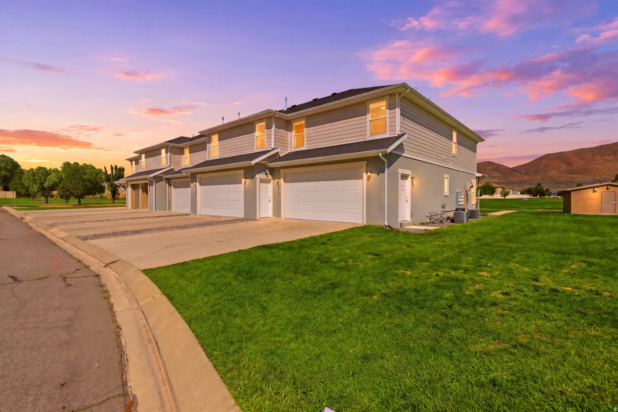 Two-story townhome with light gray siding and an attached garage