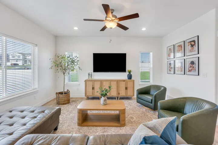 Recessed lighting, wood-finish flooring, ceiling fan, and multiple windows with blinds