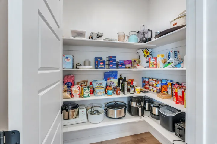 Built-in pantry shelving with white wood-finish and ample storage capacity