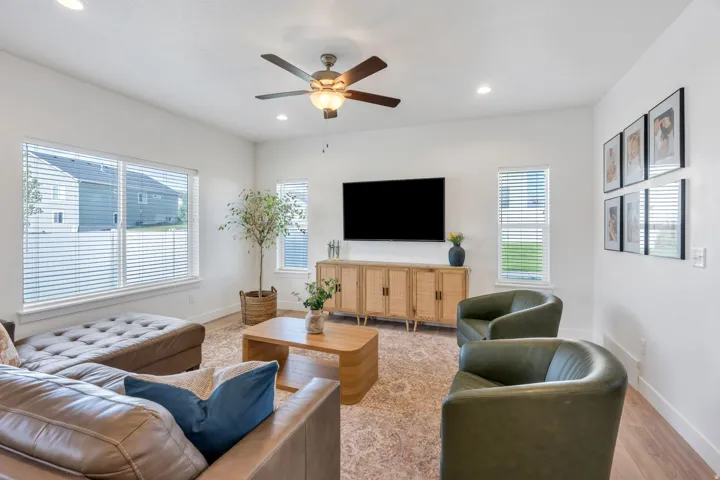 Recessed lighting, wood-finish flooring, multiple windows, and a ceiling fan with integrated lighting