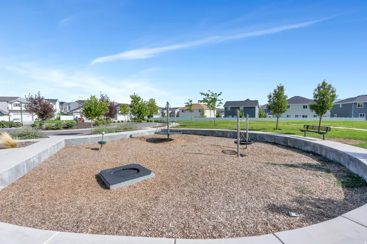 Outdoor recreational area featuring wood chip ground cover, a concrete perimeter, and mature trees
