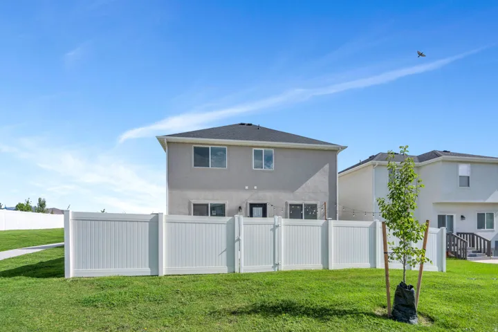 Private fenced backyard with a manicured lawn