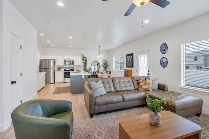 Open-concept living area featuring wood-finish flooring, recessed lighting, and a ceiling fan