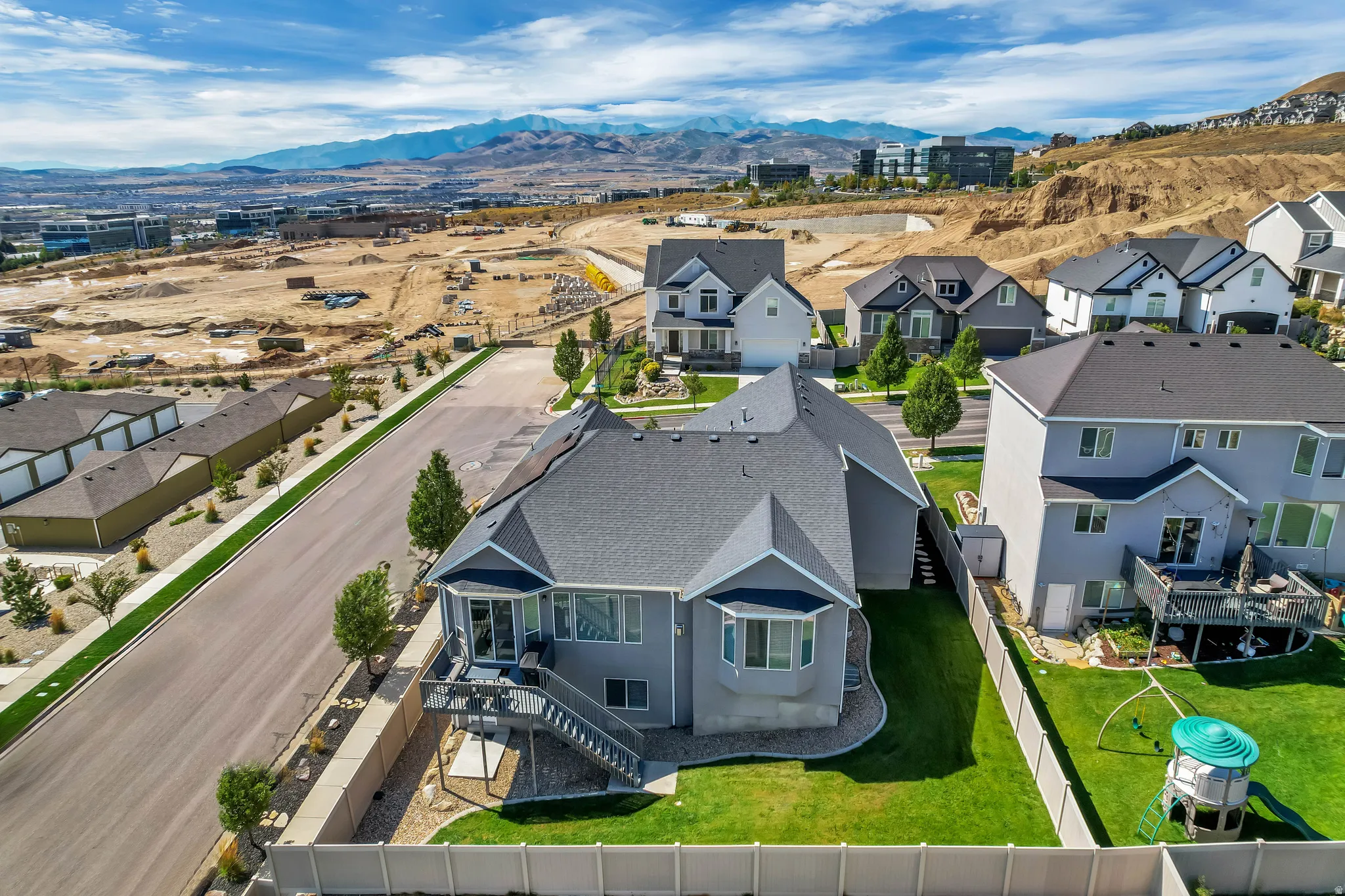 Property featuring a multi-level deck, bay windows, and a landscaped backyard